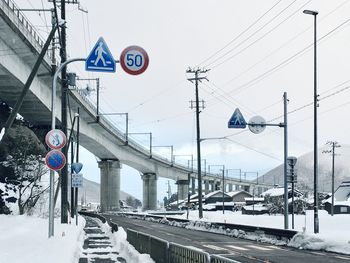 Road sign against sky during winter