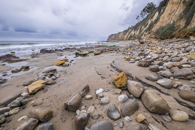 Rocks on beach against sky