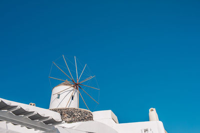 Low angle view of windmill against clear blue sky