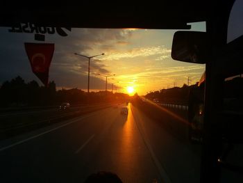 Cars on road at sunset