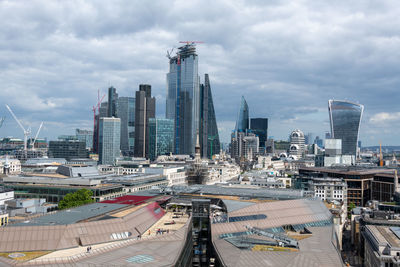 Modern buildings in city against cloudy sky