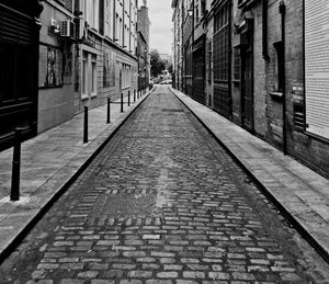 Footpath amidst buildings in city