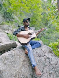 Man playing guitar on rock