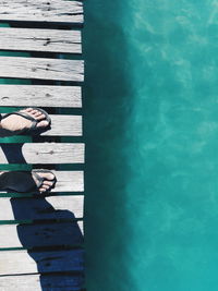 Low section of person standing by sea