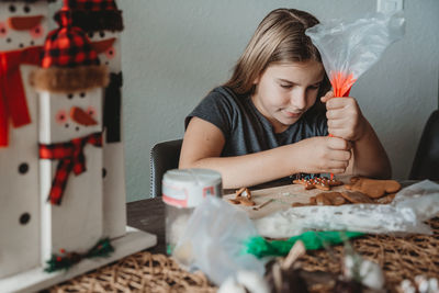 A girl decorating a holiday cookie