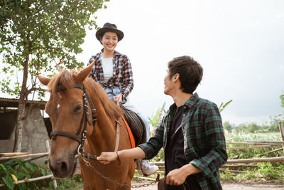 Side view of man riding horse on field