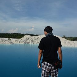 Rear view of man in sea against sky