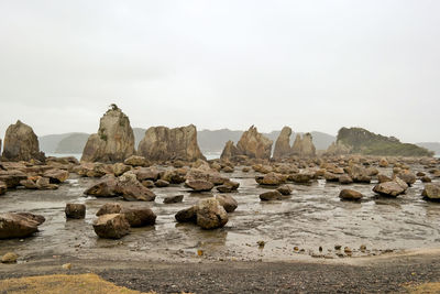 Rocks on beach against sky