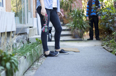 Low section of woman and man standing on footpath