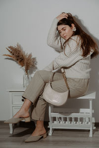 Young woman sitting on chair at home