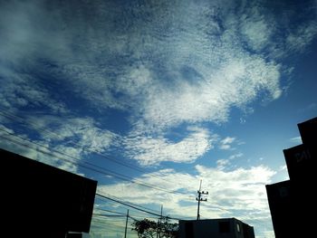 Low angle view of buildings against cloudy sky