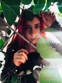 Portrait of young woman holding leaves