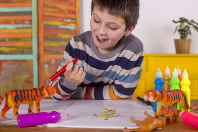 Boy with red marker pen painting a tiger