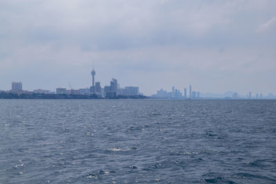 Buildings in city against cloudy sky