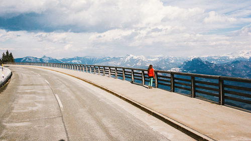 Man walking on road against sky