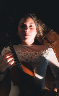 Portrait of beautiful young woman holding violin
