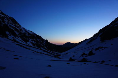 Scenic view of snowcapped mountains against clear blue sky