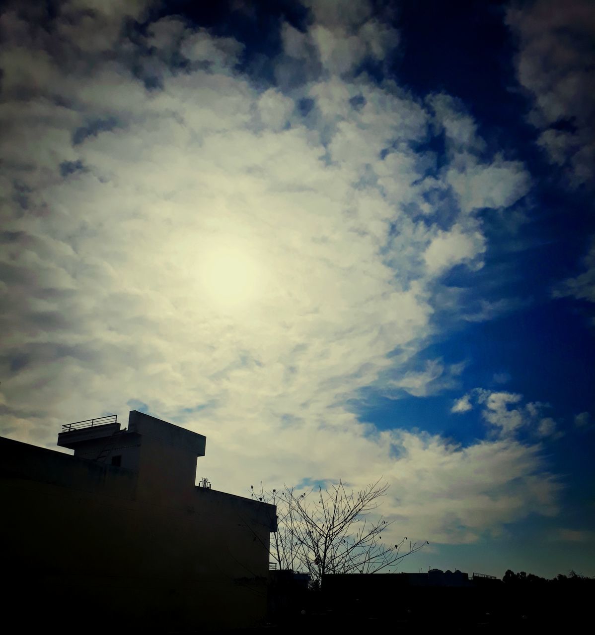 sky, cloud, sunlight, architecture, building exterior, built structure, building, nature, darkness, dusk, silhouette, evening, light, low angle view, sun, no people, sunset, residential district, city, house, horizon, tree, outdoors, reflection, blue