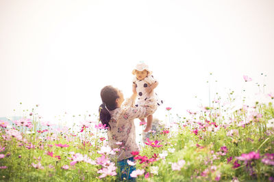View of dog on flowering plant against sky