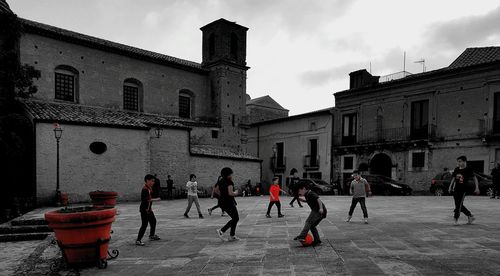 People walking on street against buildings in city