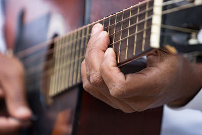 Midsection of man playing guitar