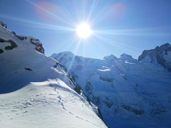 Scenic view of snowcapped mountains against sky on sunny day