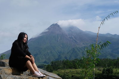 The graceful woman contemplating beside the merapi volcano