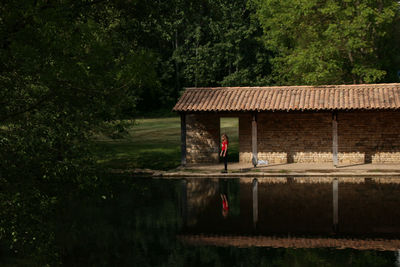 Scenic view of lake with shed by trees