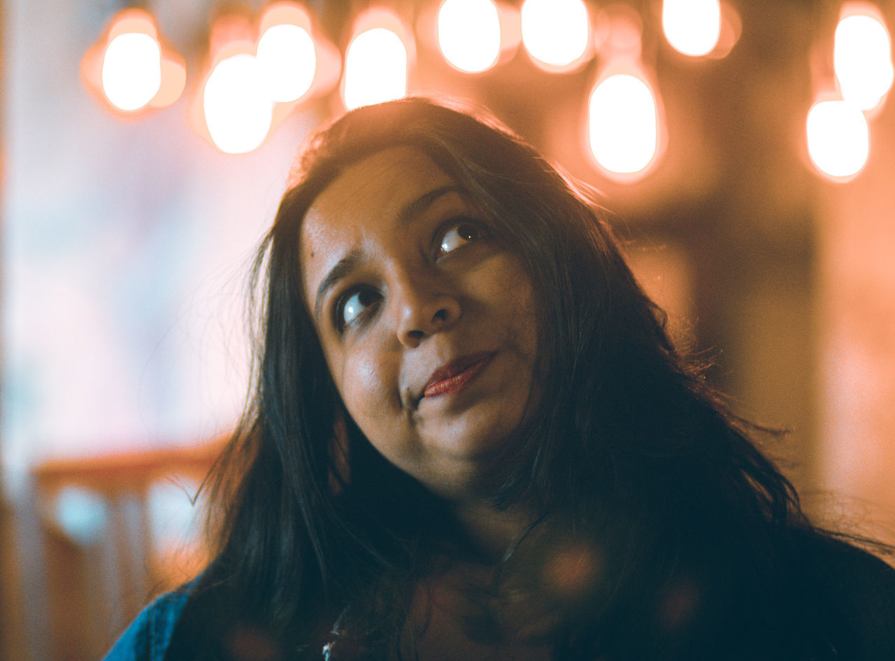 portrait, headshot, illuminated, focus on foreground, real people, lifestyles, one person, front view, young women, young adult, looking at camera, leisure activity, hair, hairstyle, women, night, close-up, indoors, glowing, lens flare, beautiful woman, human face