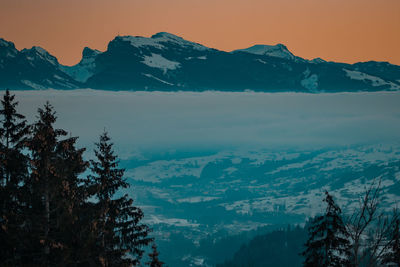 Scenic view of snowcapped mountains against sky during sunset