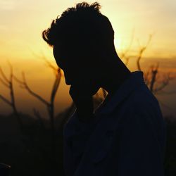 Close-up portrait of silhouette man on field against sky during sunset
