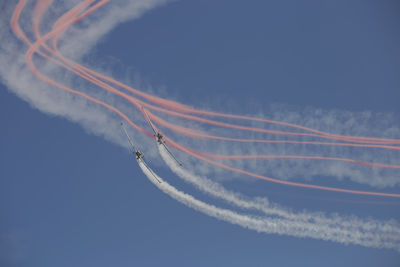 Low angle view of vapor trails against sky