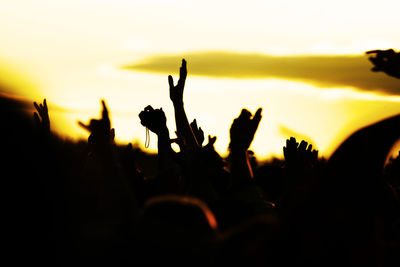 Close-up of silhouette people against sky during sunset