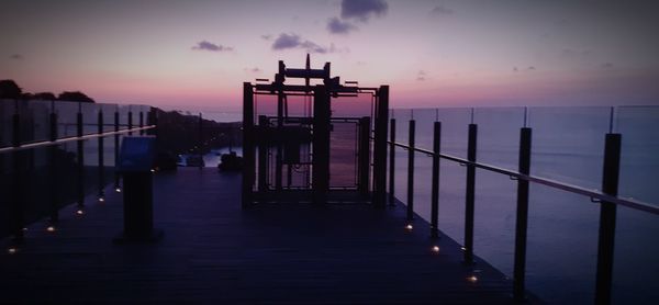 Pier over sea against sky during sunset