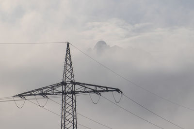 Low angle view of electricity pylon against sky