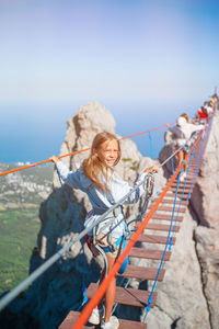 Woman standing on rope against sky