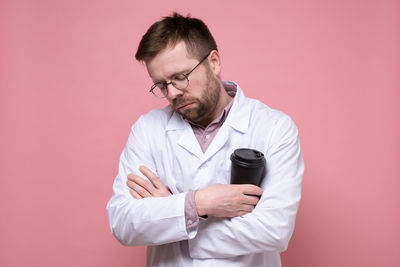 Young man looking away against wall