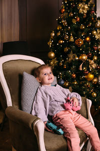 Low angle view of cute girl sitting on sofa at home