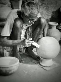 Senior man painting pot
