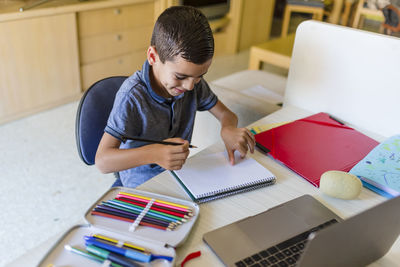 Little boy doing homework alone at home