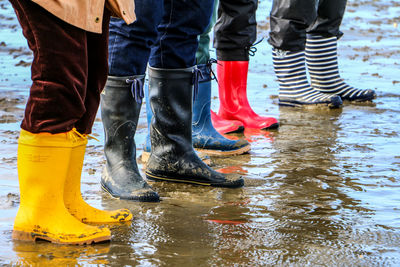 Low section of people standing on puddle