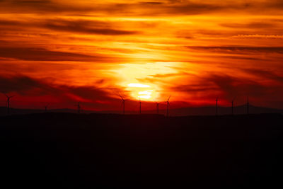 Scenic view of silhouette landscape against orange sky