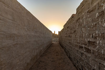 Footpath amidst buildings against sky