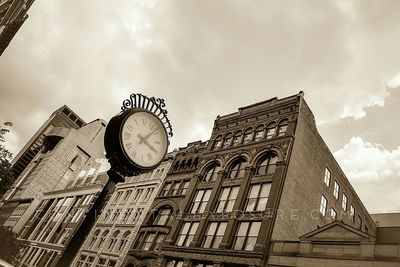 Low angle view of clock tower against cloudy sky