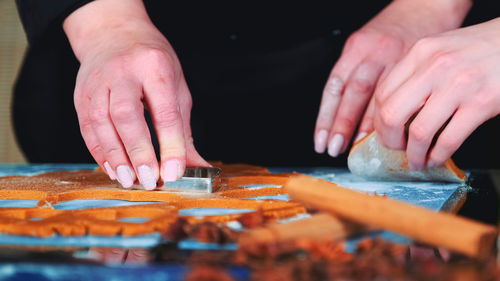 Midsection of man preparing gingerbread cookies