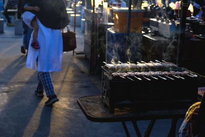 People standing on barbecue grill at market