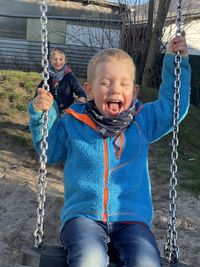 Little boy swings and laughs