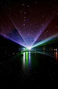 Scenic view of illuminated lake against sky at night