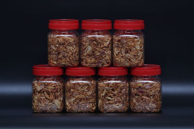 Close-up of fruits in jar on table against black background