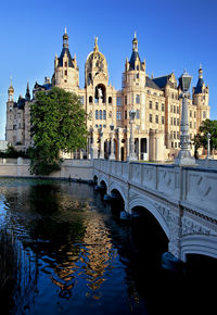 Arch bridge over river against buildings